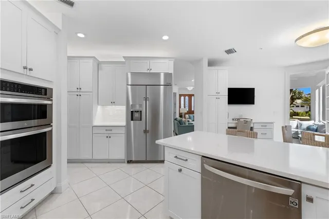 a kitchen with a sink stainless steel appliances and white cabinets