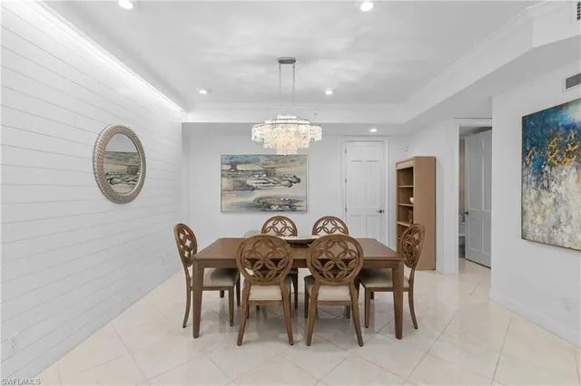 a view of a dining room that has a table and a chandelier