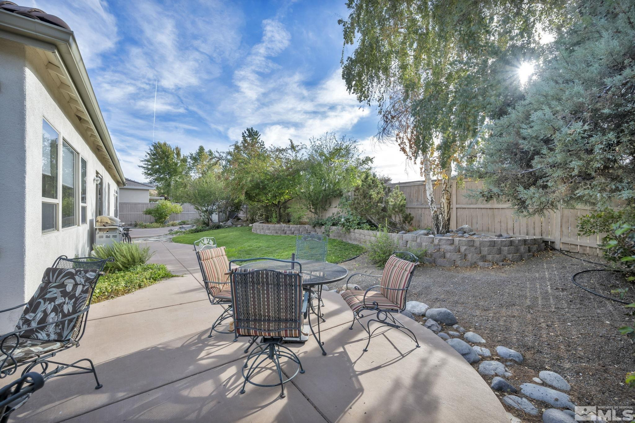 10655 Autumn Walk Lane Reno, NV 89521 - Photo 32 of 40 a view of a patio with table and chairs potted plants with wooden floor and fence