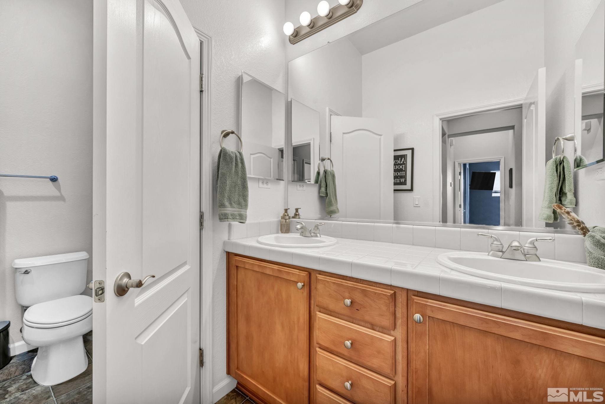 10655 Autumn Walk Lane Reno, NV 89521 - Photo 39 of 40 a bathroom with a granite countertop sink mirror vanity and toilet