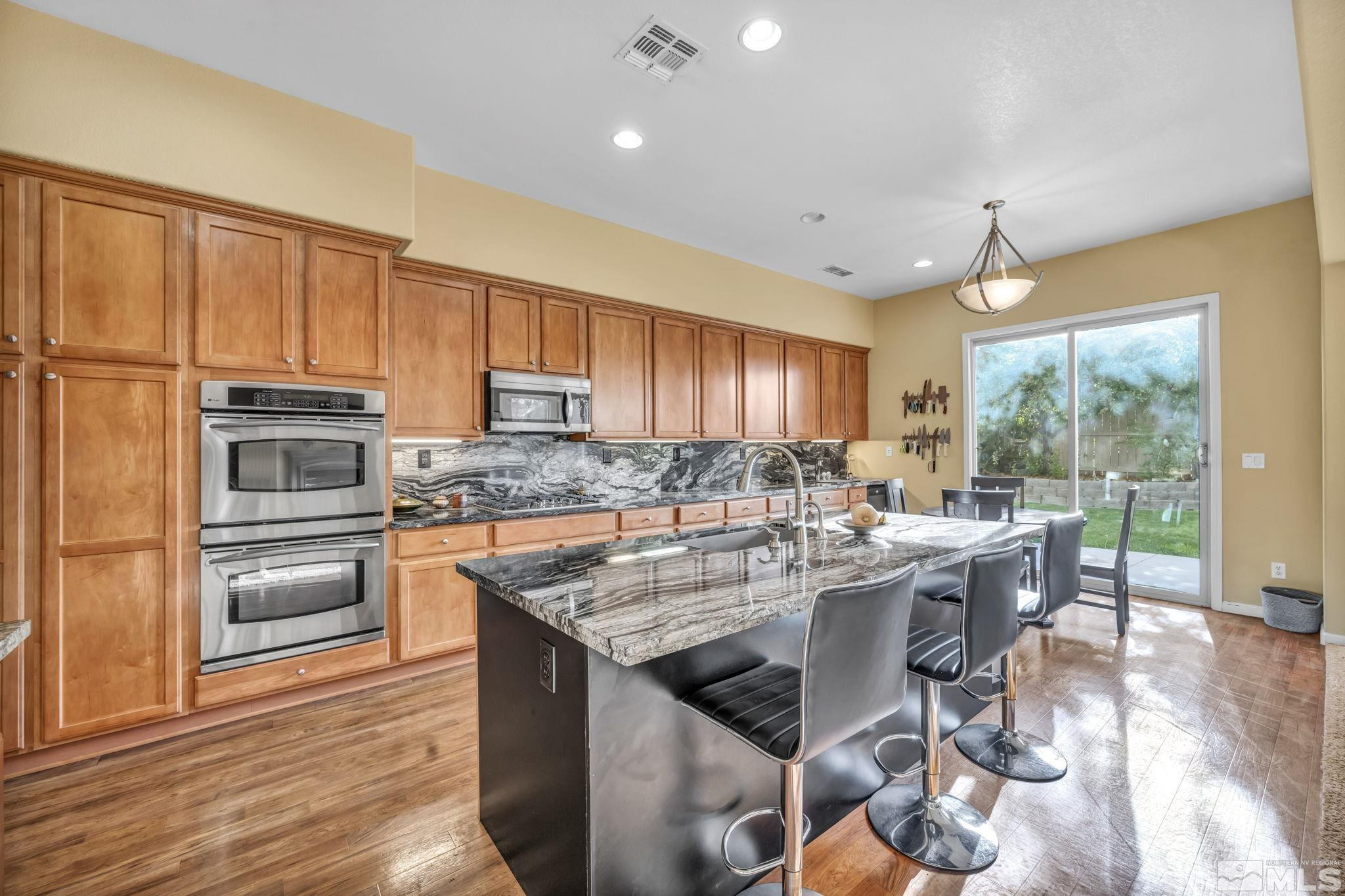 10655 Autumn Walk Lane Reno, NV 89521 - Photo 8 of 40 a kitchen with a stove a sink a microwave a dining table and chairs