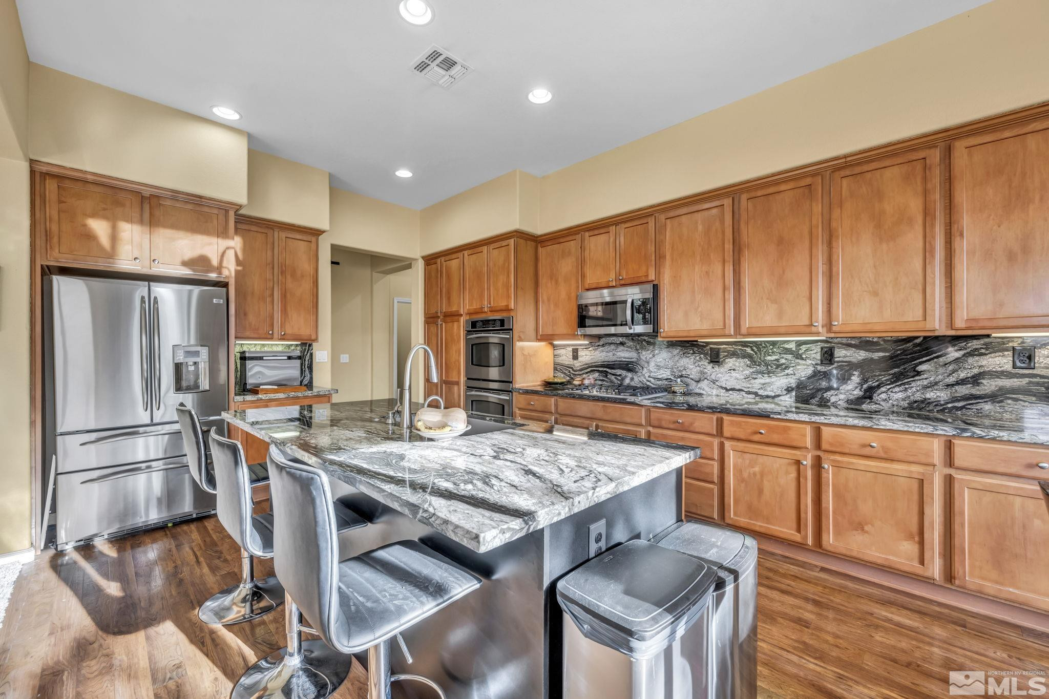 10655 Autumn Walk Lane Reno, NV 89521 - Photo 9 of 40 a kitchen with stainless steel appliances granite countertop a stove refrigerator sink and cabinets