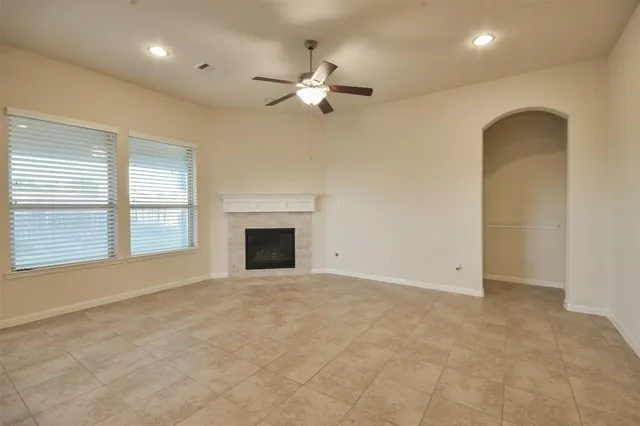 an empty room with windows and fireplace