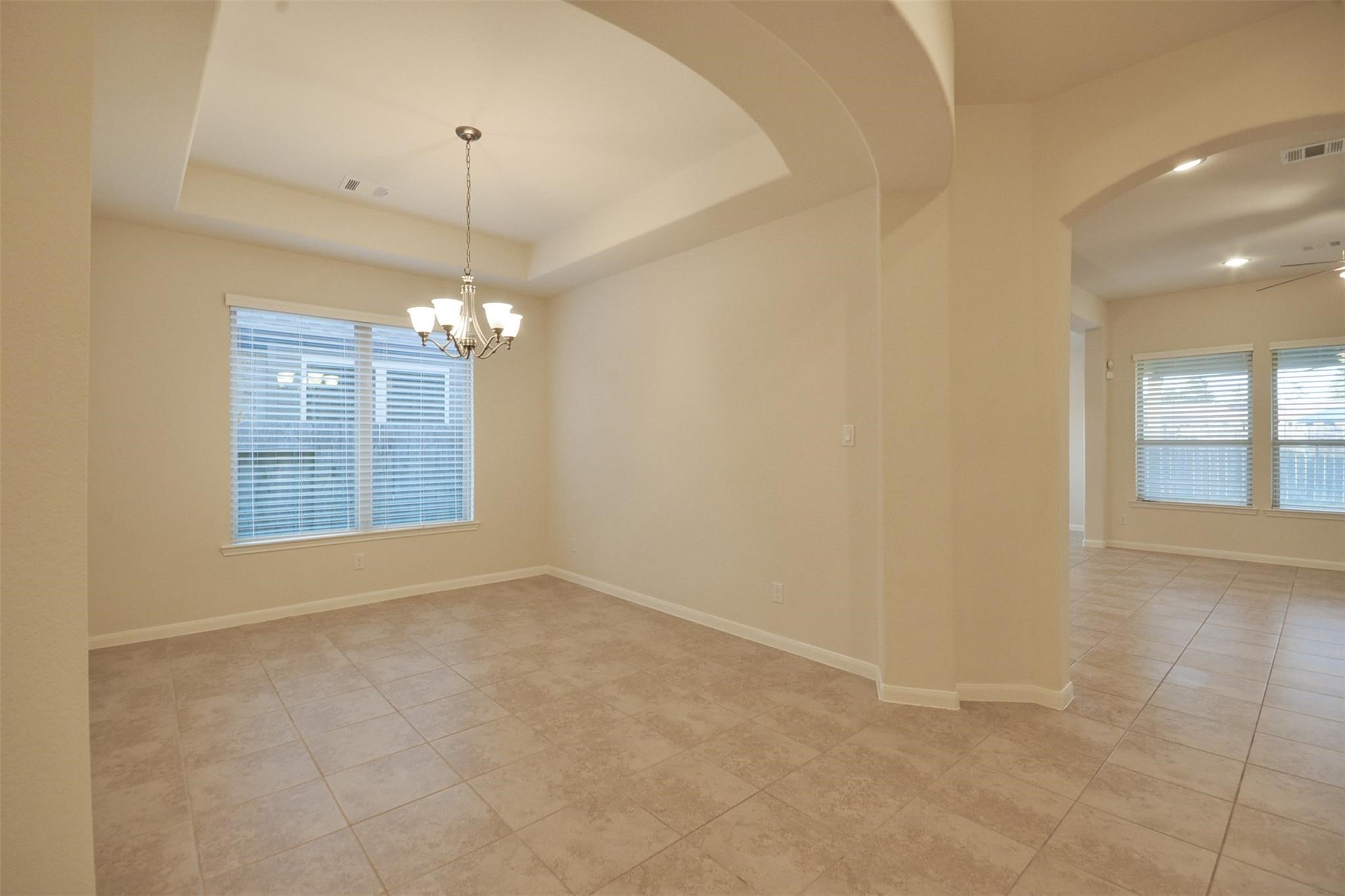 3643 Cottage Pines Lane Spring, TX 77386 - Photo 12 of 33 en empty room with chandelier fan and kitchen view