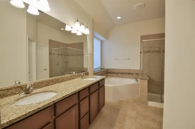 a bathroom with a granite countertop sink a large mirror and a bathtub