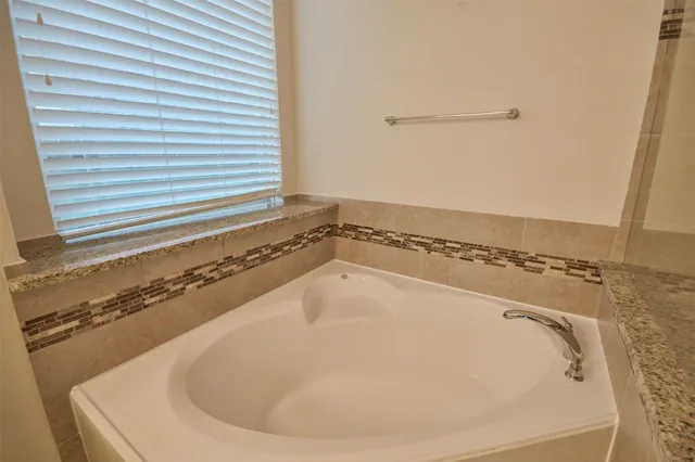 a bathroom with a bathtub and a window
