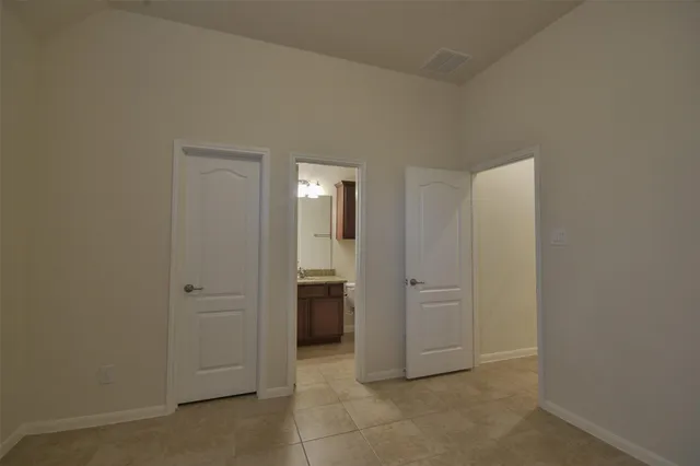 an empty room with a door and a bathroom