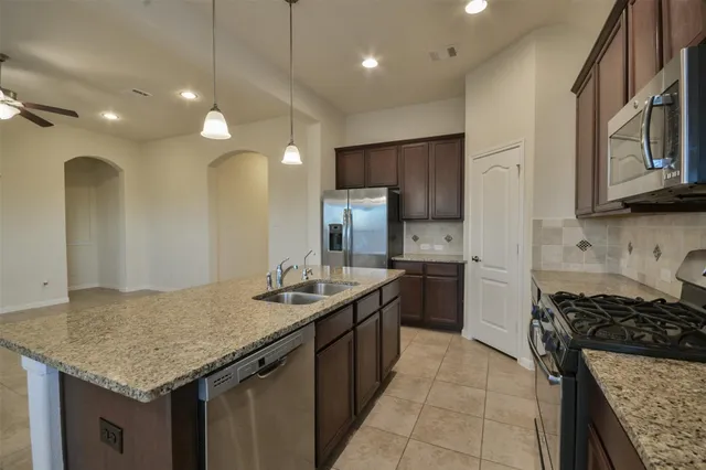 a kitchen with a kitchen island a sink stainless steel appliances and cabinets