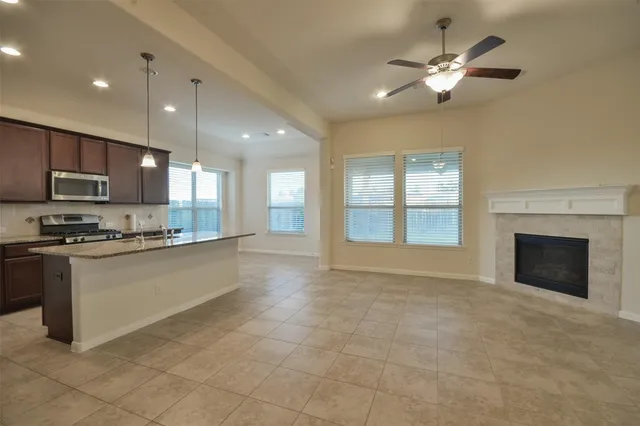 a large kitchen with granite countertop a stove top oven a sink a counter space and cabinets