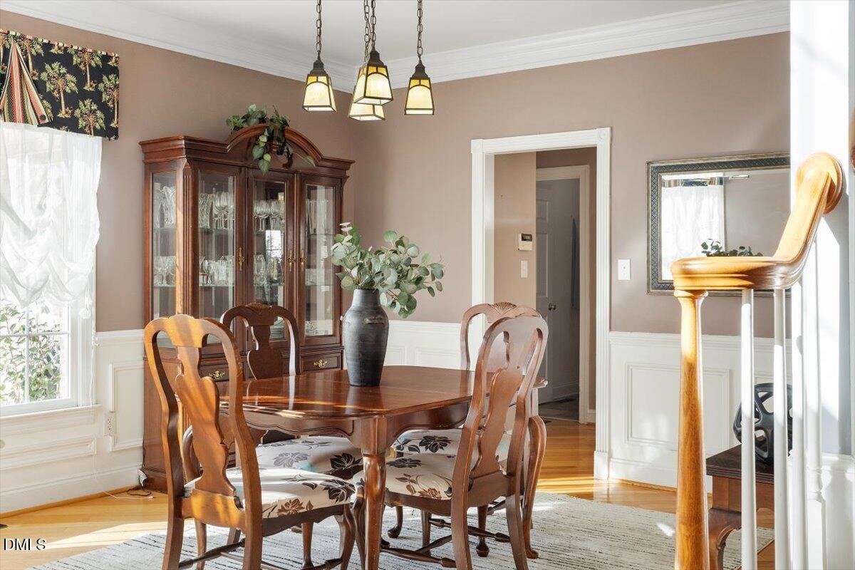 9120 Sanctuary Court Raleigh, NC 27617 - Photo 12 of 80 a dining room with furniture a chandelier and wooden floor