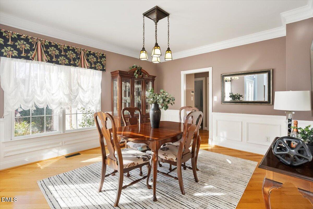 9120 Sanctuary Court Raleigh, NC 27617 - Photo 13 of 80 a dining room with furniture a chandelier and wooden floor