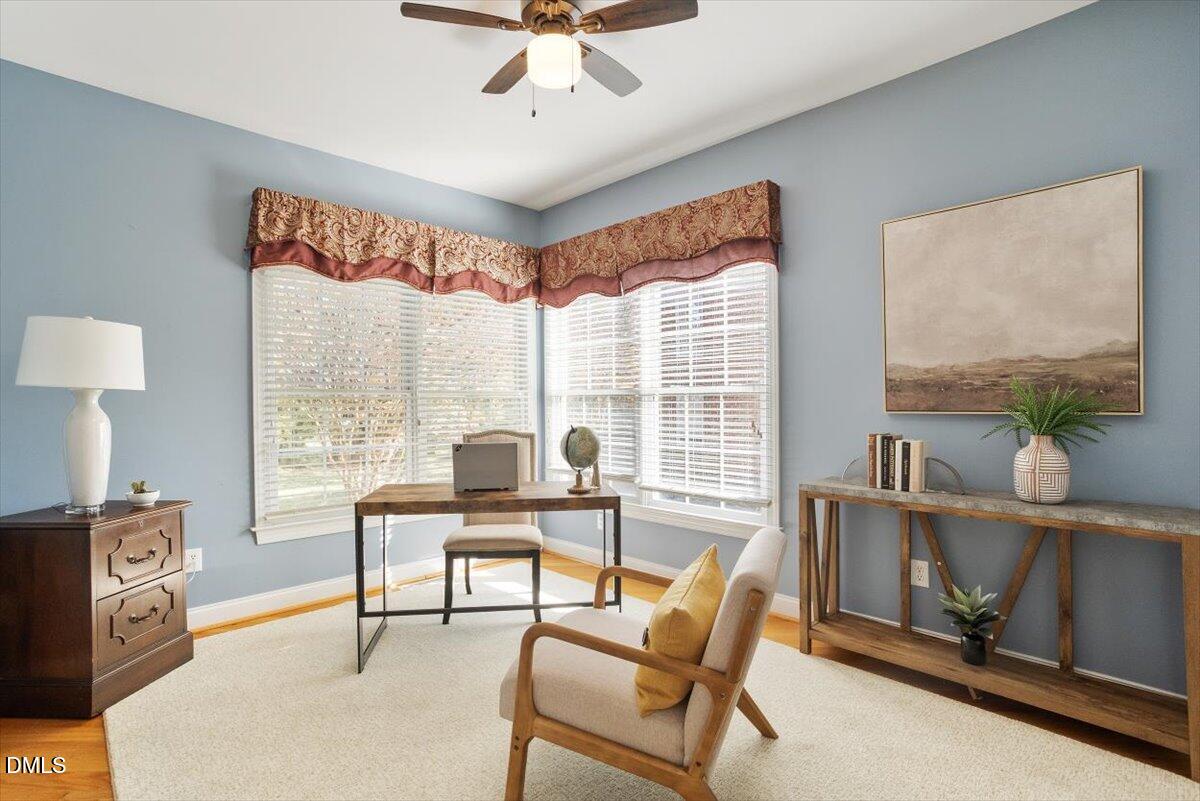 9120 Sanctuary Court Raleigh, NC 27617 - Photo 17 of 80 a living room with furniture a flat screen tv and a floor to ceiling window