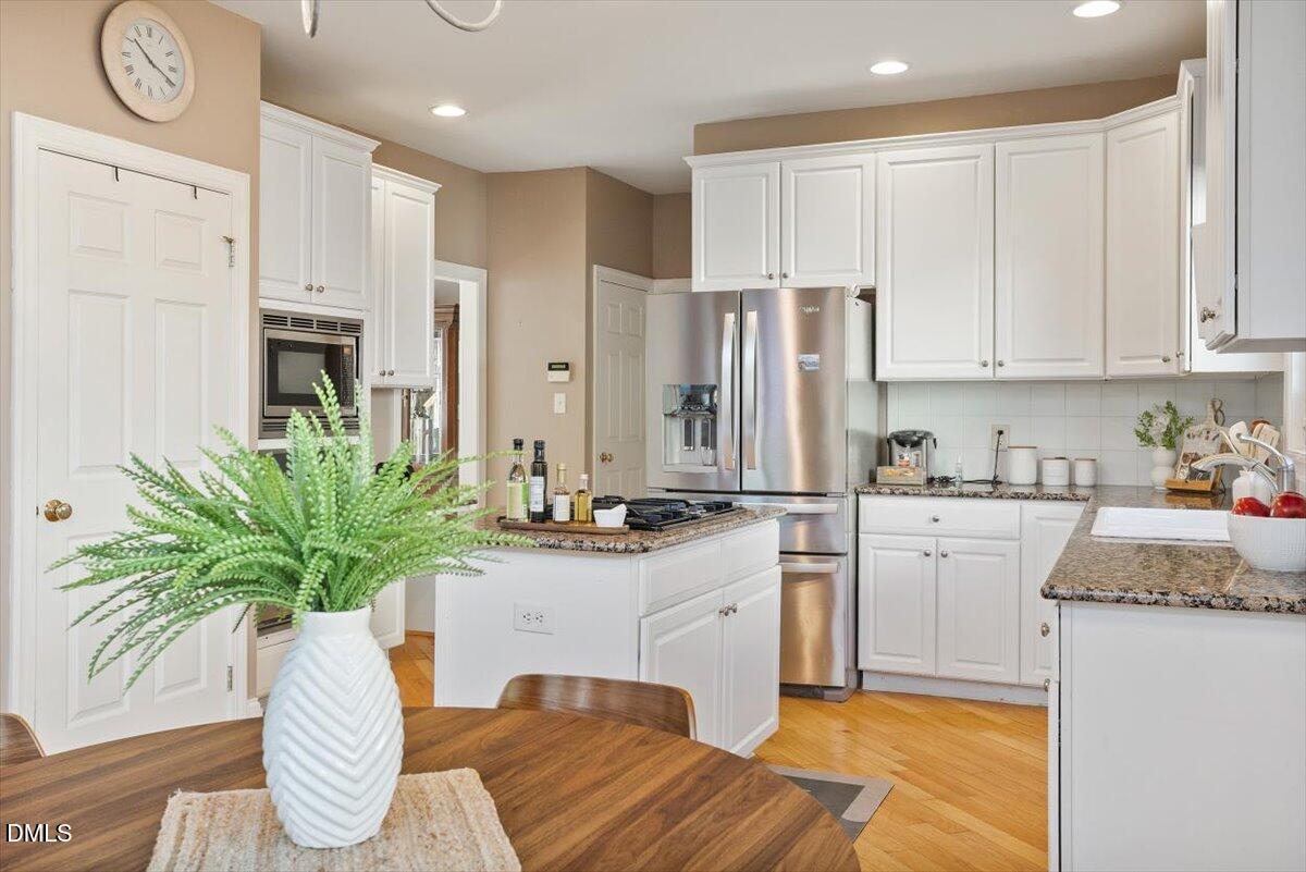 9120 Sanctuary Court Raleigh, NC 27617 - Photo 27 of 80 a kitchen with stainless steel appliances granite countertop a refrigerator a stove a sink and white cabinets