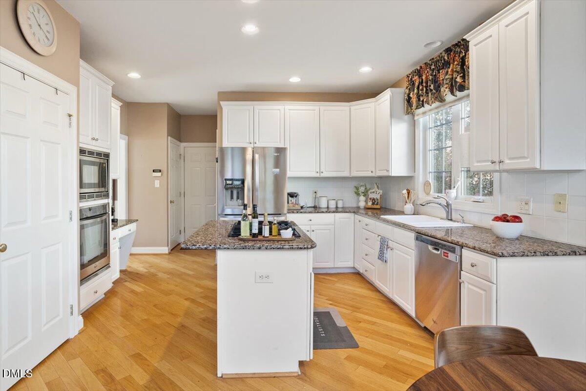 9120 Sanctuary Court Raleigh, NC 27617 - Photo 28 of 80 a kitchen with stainless steel appliances kitchen island granite countertop a stove a sink and a refrigerator