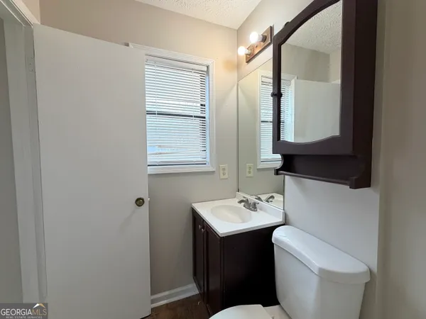 a bathroom with a toilet sink and mirror