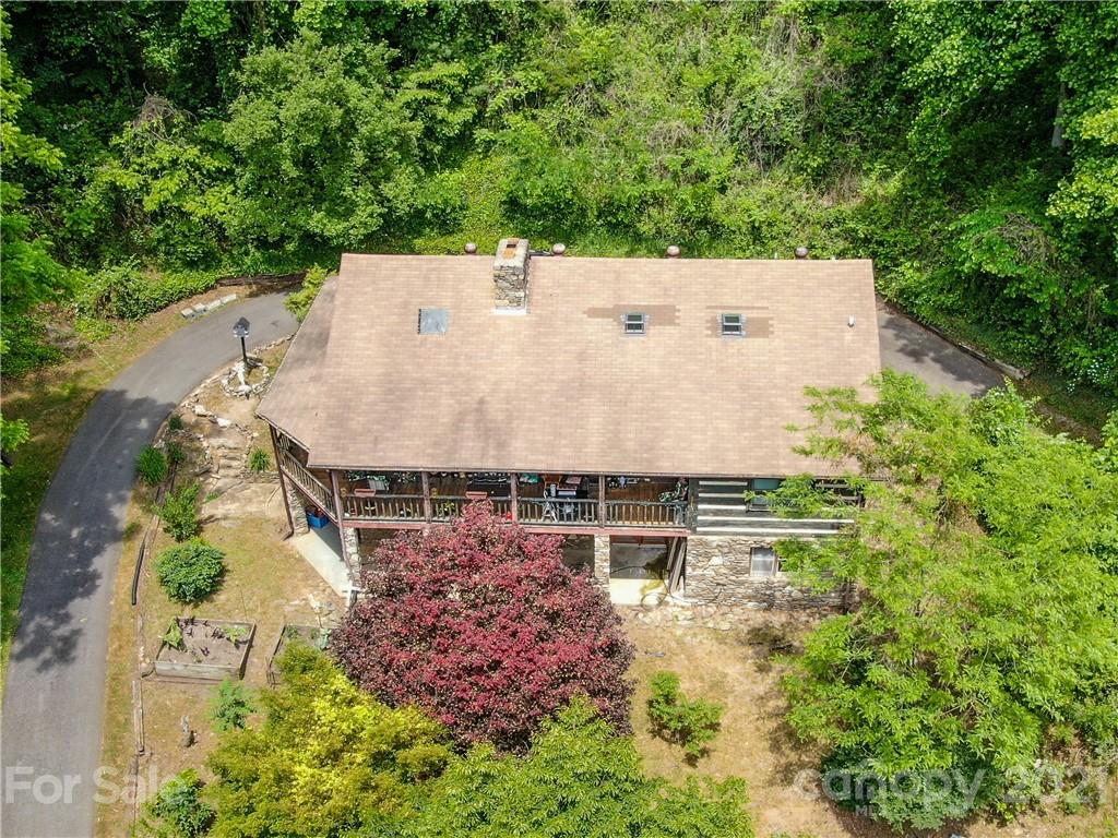 an aerial view of a house with a yard and large trees