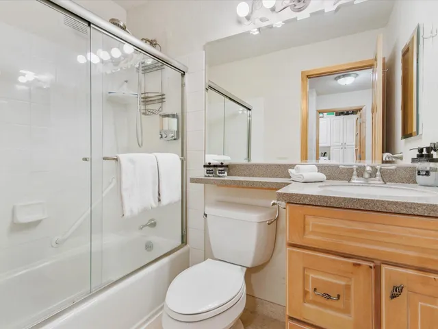a bathroom with a granite countertop sink toilet and shower