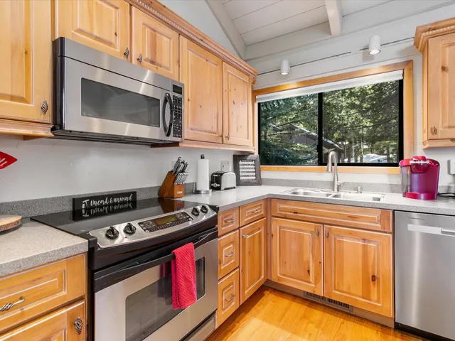 a kitchen with stainless steel appliances a sink a stove and cabinets