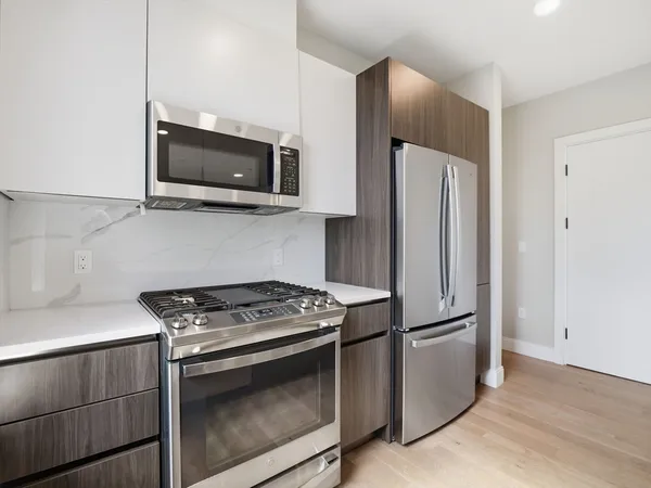 a kitchen with stainless steel appliances white cabinets and a stove top oven