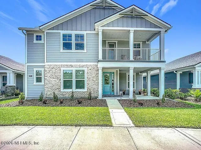 a front view of a house with a yard and outdoor seating