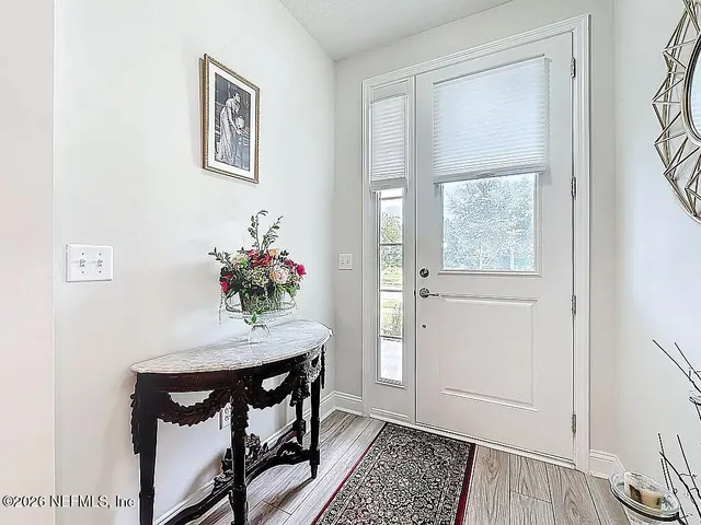 a view of entryway and hall with wooden floor