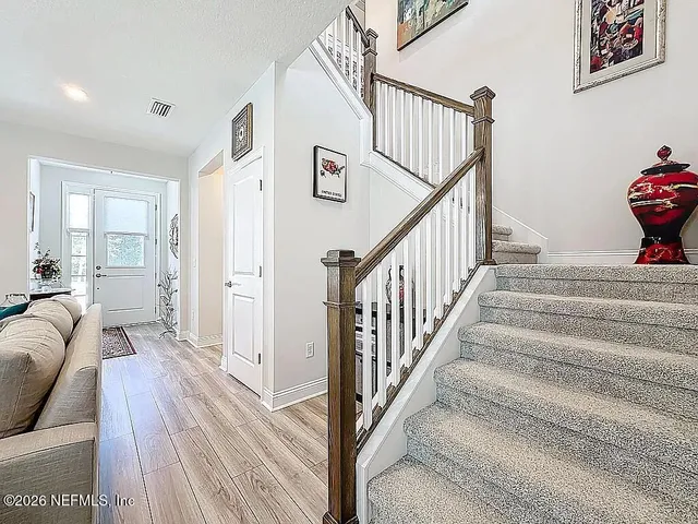 a kitchen with a table chairs refrigerator microwave and wooden floor