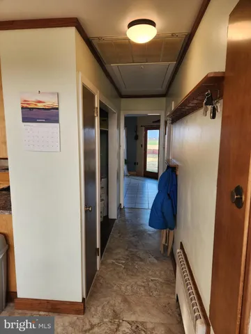 a view of a hallway with wooden floor and closet