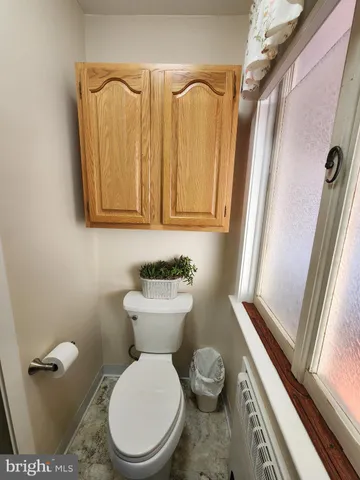 a living room with furniture a bookshelf and a window