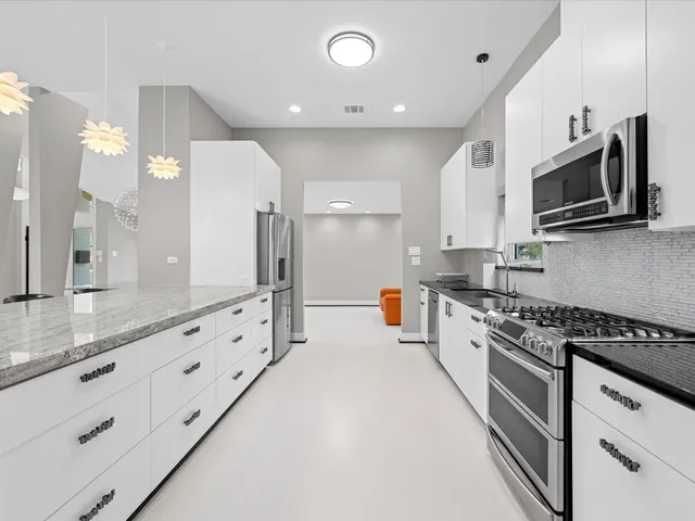 a large kitchen with granite countertop a stove and a sink