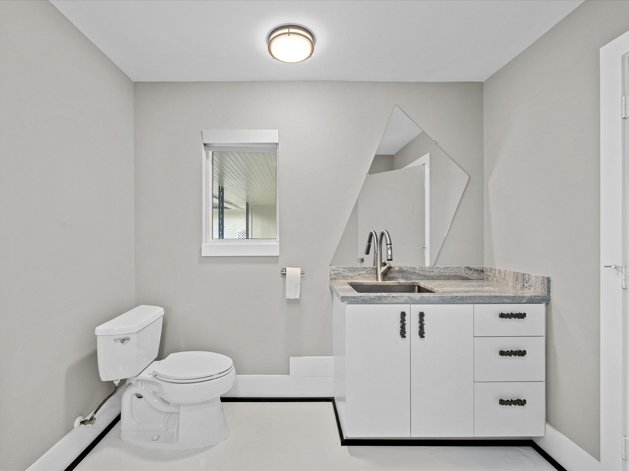 5603 Grape Street Houston, TX 77096 - Photo 18 of 40 a bathroom with a granite countertop sink a toilet and mirror