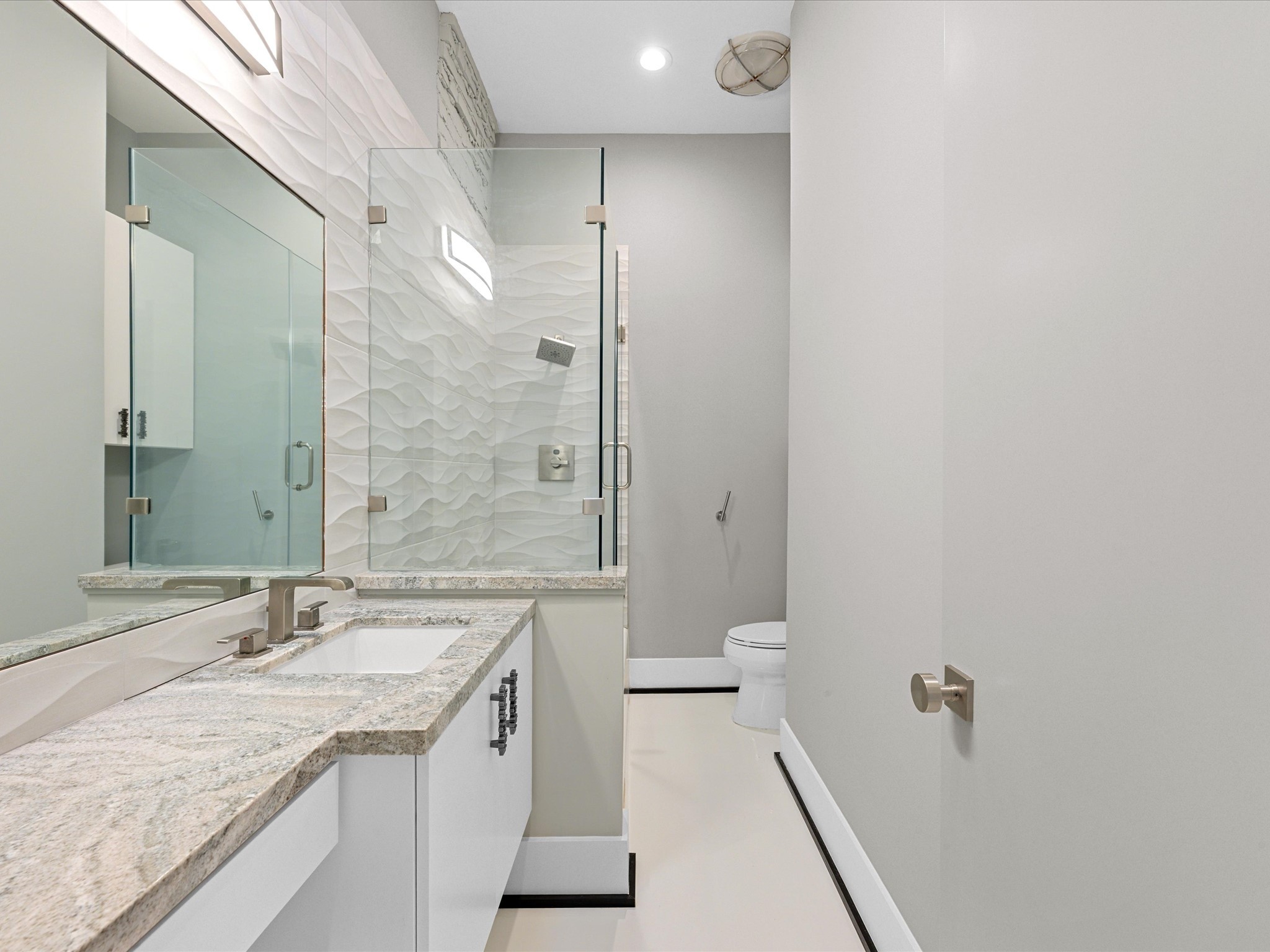 5603 Grape Street Houston, TX 77096 - Photo 19 of 40 a bathroom with a granite countertop sink a toilet and shower