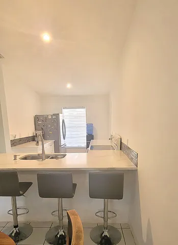 a living room with furniture a chandelier and view of dining room