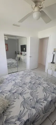 a bedroom with a bed and a lamp on the dresser