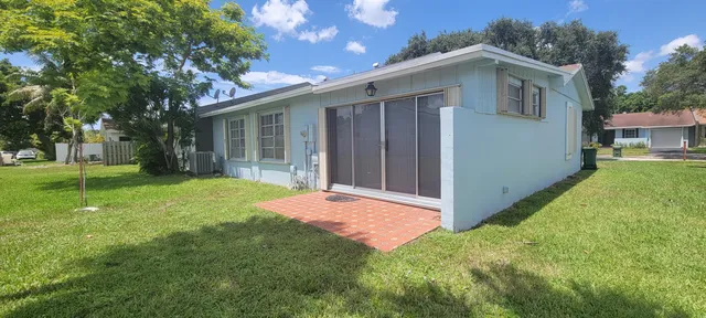 a front view of a house with a garden and trees