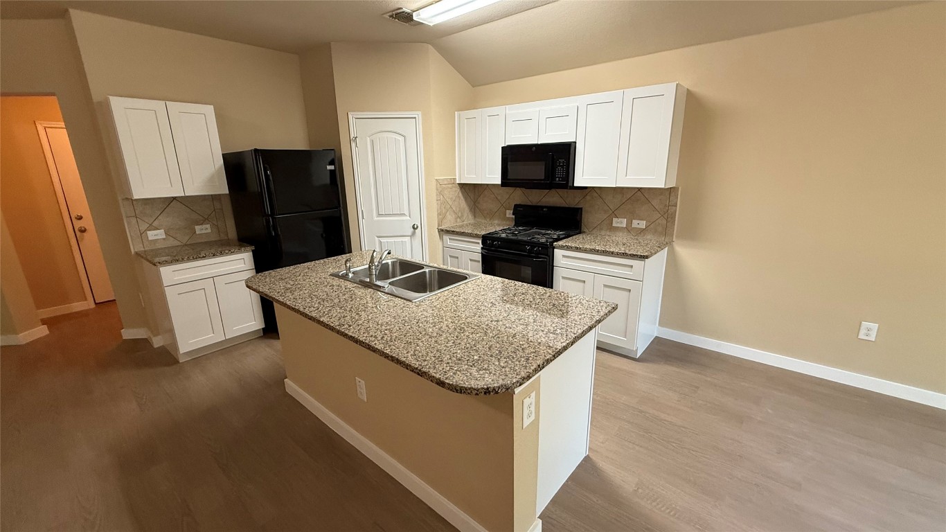 804 Red Tails Drive Austin, TX 78725 - Photo 5 of 14 a kitchen with granite countertop cabinets stainless steel appliances and a counter space