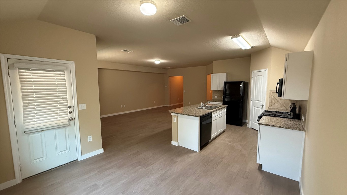 804 Red Tails Drive Austin, TX 78725 - Photo 6 of 14 a kitchen with sink cabinets and refrigerator