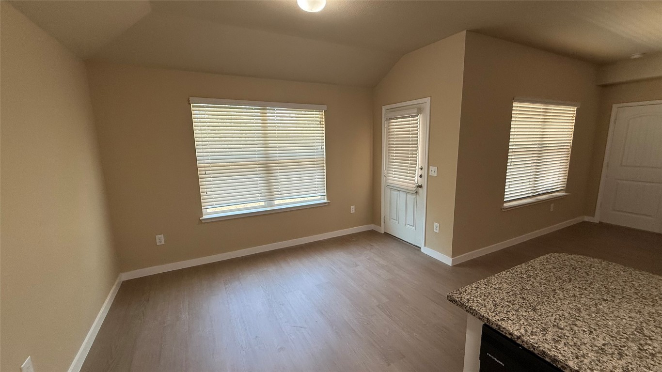 804 Red Tails Drive Austin, TX 78725 - Photo 7 of 14 an empty room with wooden floor and windows