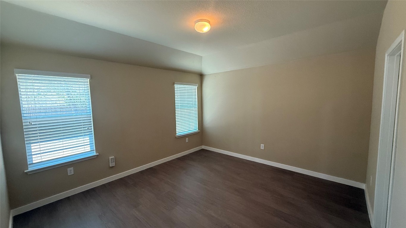 804 Red Tails Drive Austin, TX 78725 - Photo 9 of 14 an empty room with wooden floor and windows