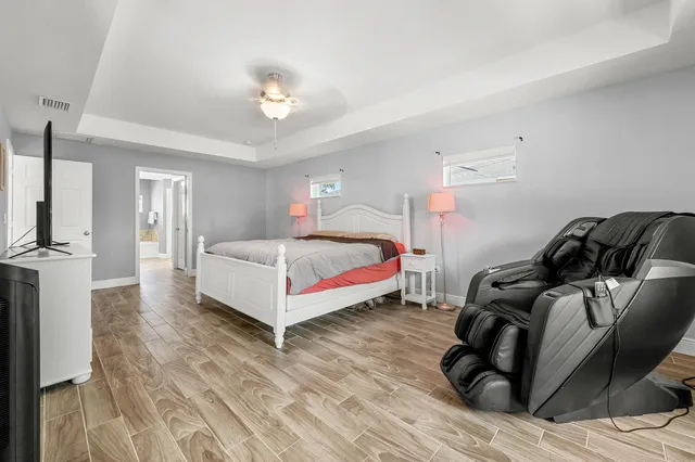 a spacious bedroom with a bed and a chandelier