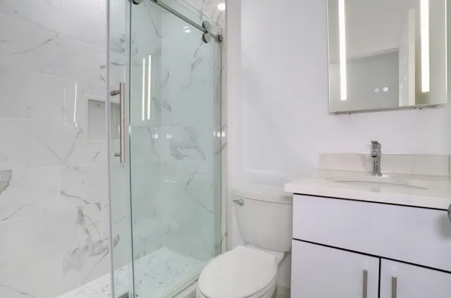 a bathroom with a toilet sink and mirror
