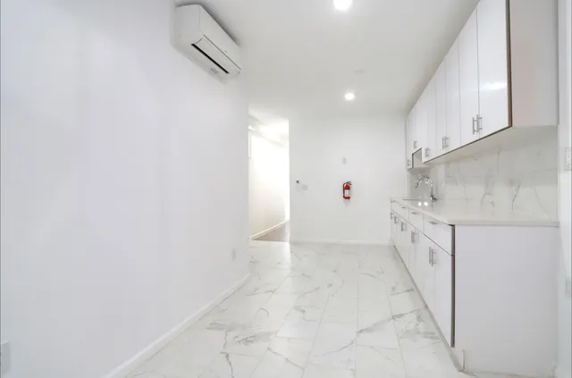 a view of a kitchen with white cabinets