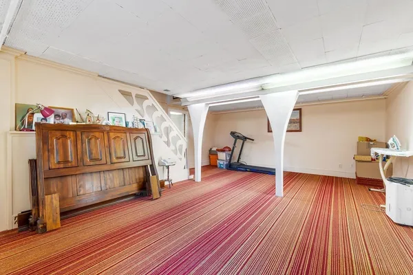 a living room with a bed and a wooden floor