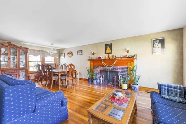 a living room with furniture a dining table and chairs with wooden floor