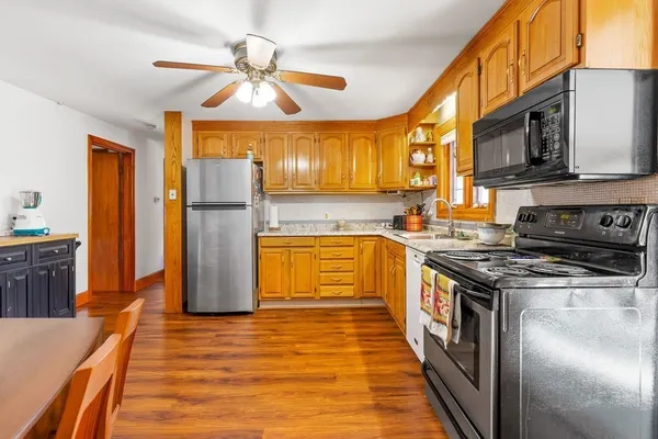 a kitchen with stainless steel appliances granite countertop a stove a refrigerator and a microwave oven with cabinets
