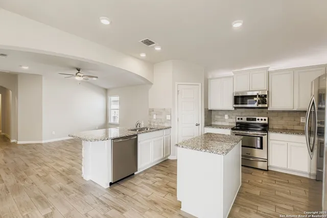 a kitchen with stainless steel appliances a sink stove and refrigerator
