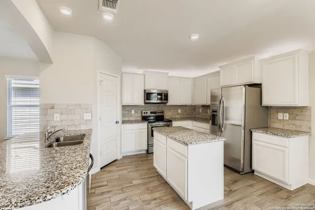 a kitchen with a stove a refrigerator and a sink
