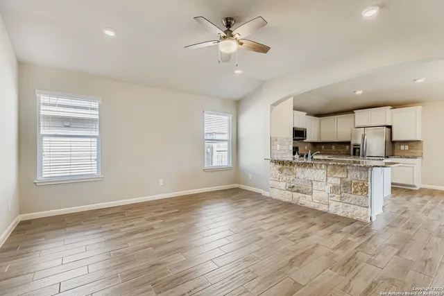 a view of kitchen with refrigerator stove and wooden floor
