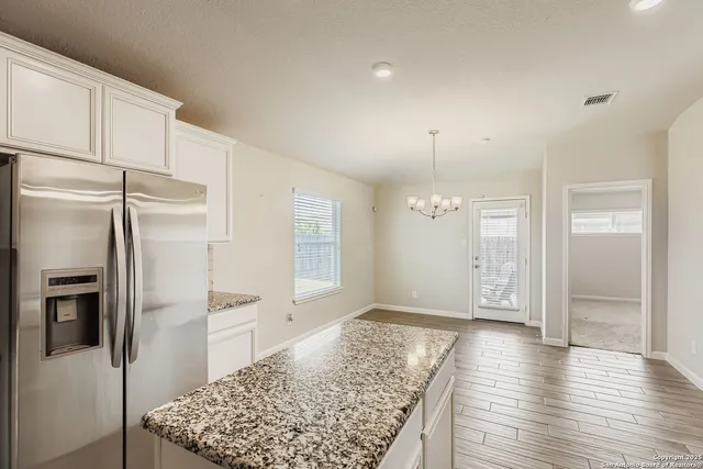 a view of a kitchen with a refrigerator cabinets and wooden floor