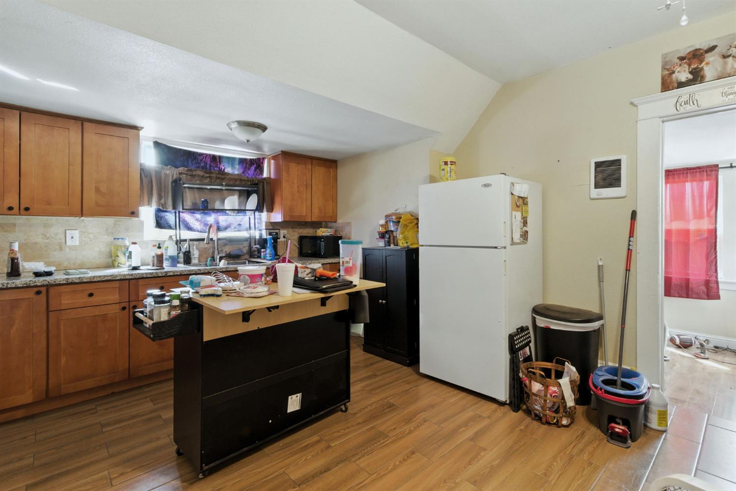 312 West Main Street Turlock, CA 95380 - Photo 33 of 84 a kitchen with a refrigerator a stove and wooden floor