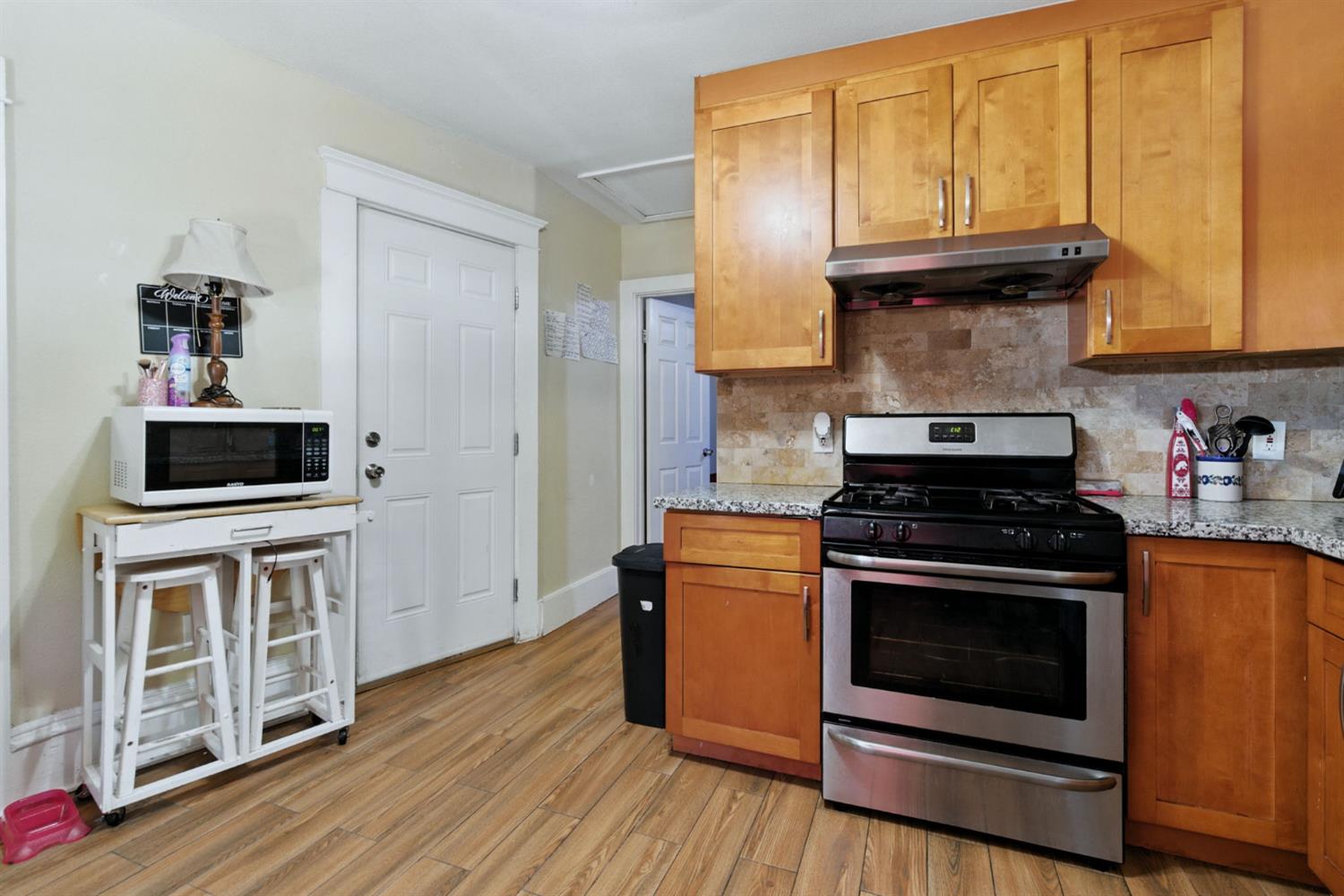 312 West Main Street Turlock, CA 95380 - Photo 43 of 84 a kitchen with stainless steel appliances granite countertop a stove and a microwave